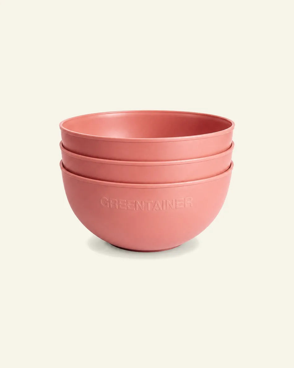 Three stacked matte pink bowls with the brand name GREENTAINER embossed on the front, set against a solid off-white background.