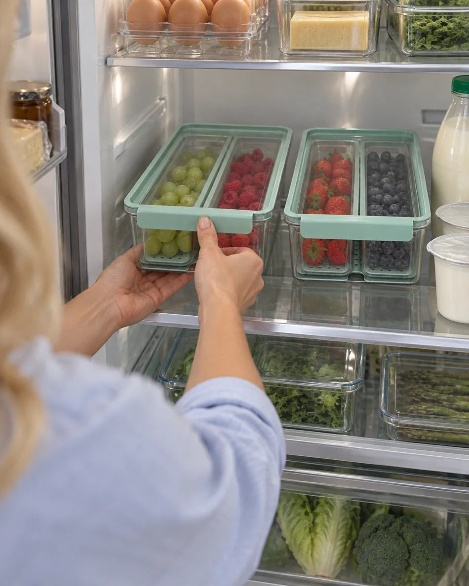 Returning a filled storage box to an organized fridge shelf